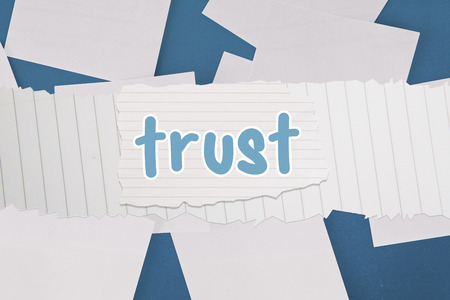 The word trust against white paper strewn over blueの写真素材