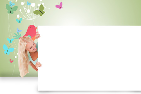 Composite image of pretty blonde showing white cardの写真素材