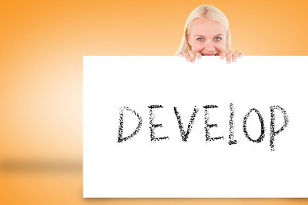 Pretty blonde showing card with develop against orange backgroundの写真素材