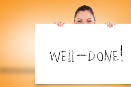 Pretty brunette showing card with well done against orange backgroundの写真素材