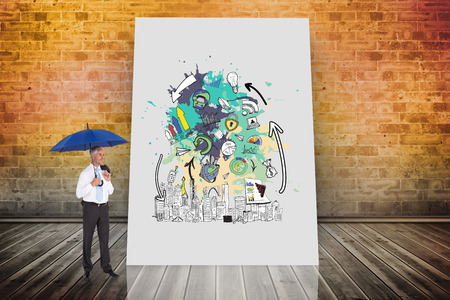 Composite image of happy businessman holding umbrella against white cardの写真素材