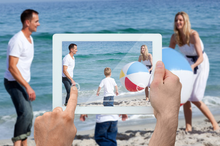 Hand holding tablet pc against many feathers blowing in the breezeの写真素材