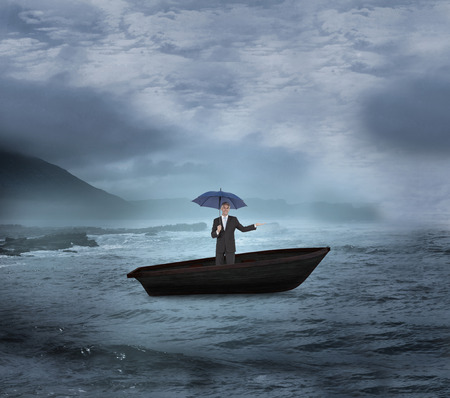 Composite image of peaceful businessman holding blue umbrella in a sailboat on open waterの写真素材