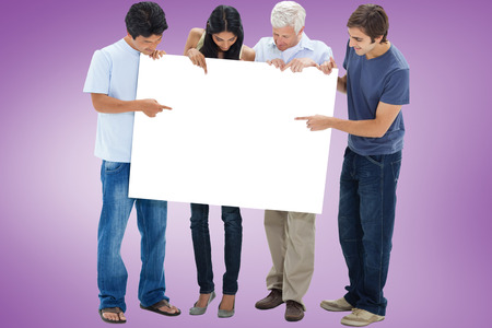 Casual group showing card against purple vignetteの写真素材