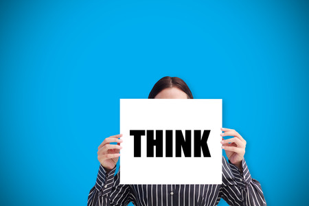 Businesswoman holding card saying think against blue background with vignetteの写真素材