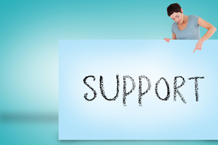 Pretty brunette showing card with support against blue backgroundの写真素材