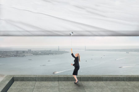 Businesswoman pulling a white screen against coastline cityの写真素材