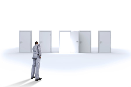 Thinking businessman against door opening revealing bright lightの写真素材