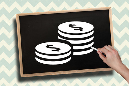 Composite image of hand drawing coins with chalk on chalkboard with wooden frameの写真素材