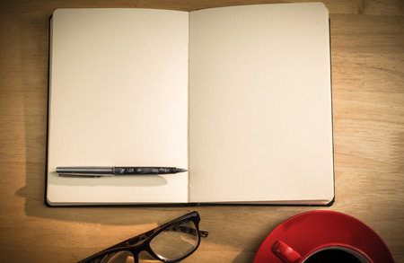 Overhead of notepad and pen and coffee on a deskの写真素材