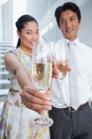 Happy couple dressed up for a date having champagne on the stairsの写真素材