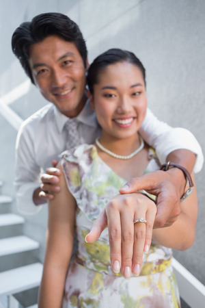 Couple showing engagement ring on womans finger on the stairsの写真素材