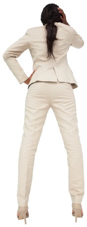 Thinking businesswoman in cream suit on white backgroundの写真素材
