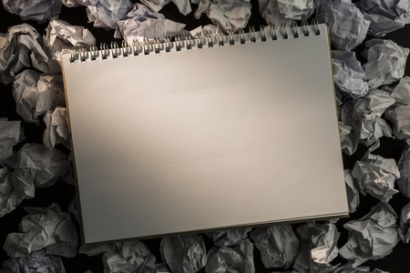Paper notebook on crumpled paper on dark backgroundの写真素材