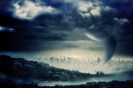 Digitally generated stormy sky with tornado over cityscapeの写真素材