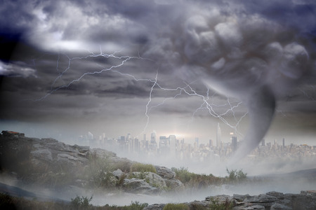 Digitally generated stormy sky with tornado over cityscapeの写真素材