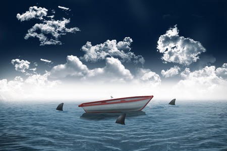 Digitally generated sharks circling small boat in the seaの写真素材