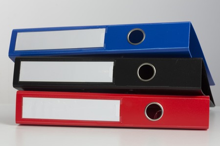 Stack of three business binders on white surfaceの写真素材