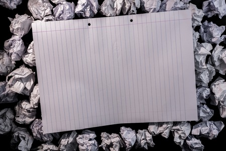 Lined paper notebook on crumpled paper on dark backgroundの写真素材