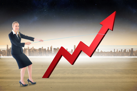 Businesswoman pulling a rope around arrow against cityscape on the horizonの写真素材