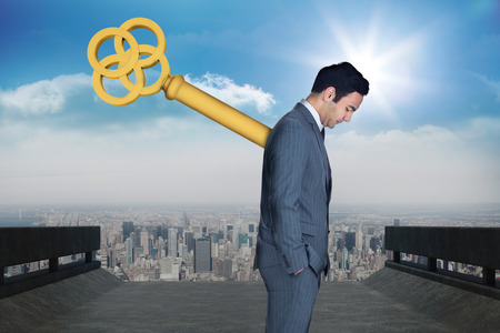 Wound up businessman with hands in pockets against road leading to cityの写真素材