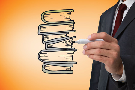 Composite image of businessman drawing books against orange vignetteの写真素材