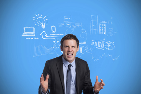 Stressed businessman gesturing against blue background with vignetteの写真素材