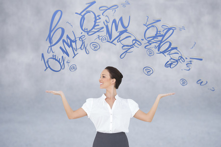 Happy elegant businesswoman posing with letters against grey wallの写真素材