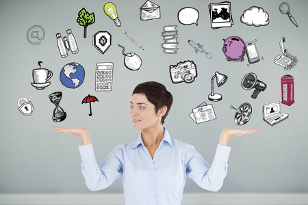 Businesswoman with an open hand to show graphics against room with wooden floorの写真素材