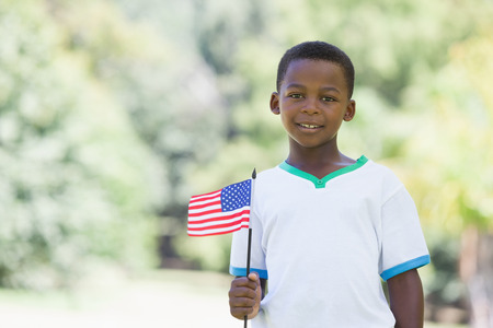 Little boy celebrating independence day in the park on a sunny dayの写真素材