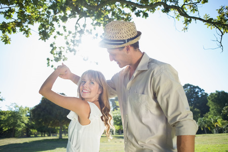 Cute couple dancing in the park on a sunny dayの写真素材