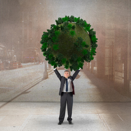 Composite image of businessman holding green sphere against urban projection on wallの写真素材