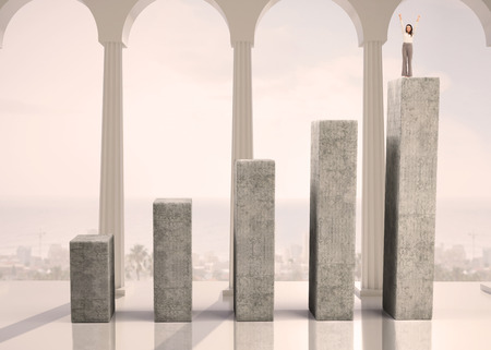 Cheerful businesswoman on bar chart depicting growthの写真素材