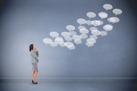 Focused businesswoman against speech bubbles