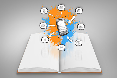 Smartphone apps on paint splashes on open book against grey vignetteの写真素材