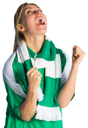 Cheering football fan in green jersey on white backgroundの写真素材
