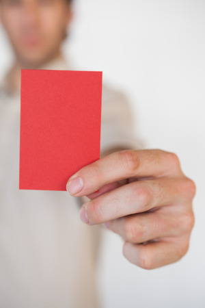 Casual businessman showing red card in the officeの写真素材