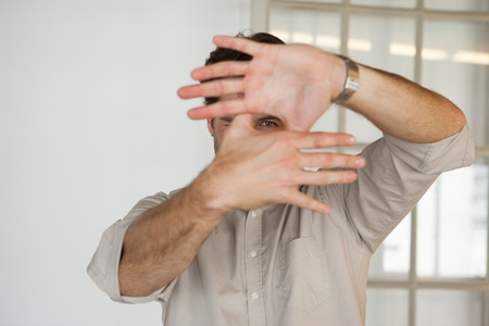Casual businessman framing with his hands in his officeの写真素材