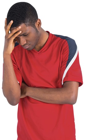 Disappointed football fan looking down on white backgroundの写真素材