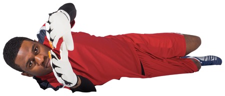 Goalkeeper in red making a save on white backgroundの写真素材