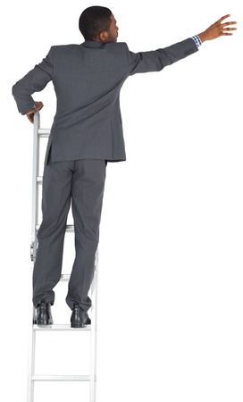 Businessman standing on ladder on white backgroundの写真素材