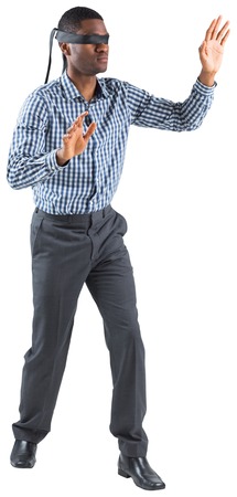 Blindfolded businessman with arms out on white backgroundの写真素材