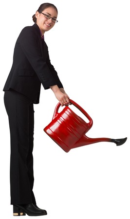 Businesswoman using red watering can on white backgroundの写真素材