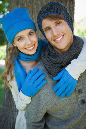 Cute couple embracing in the park smiling at camera on a sunny dayの写真素材
