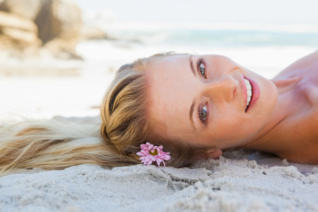 Pretty carefree blonde lying on the beach on a sunny dayの写真素材