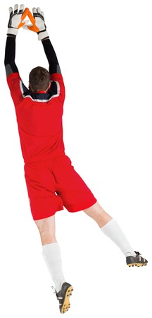 Goalkeeper in red jumping up on white backgroundの写真素材