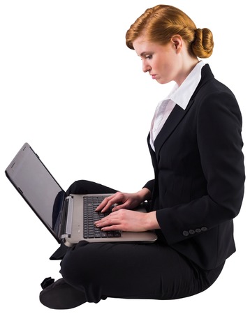 Redhead businesswoman using her laptop on white backgroundの写真素材