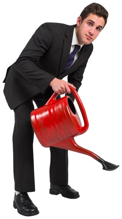 Businessman watering with red can on white backgroundの写真素材