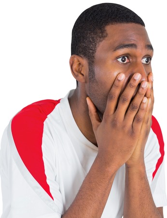 Nervous football fan looking ahead on white backgroundの写真素材