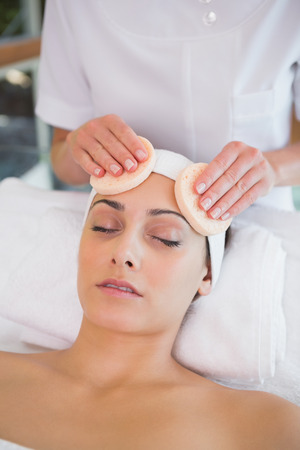 Peaceful brunette getting facial from beauty therapist in the health spaの写真素材